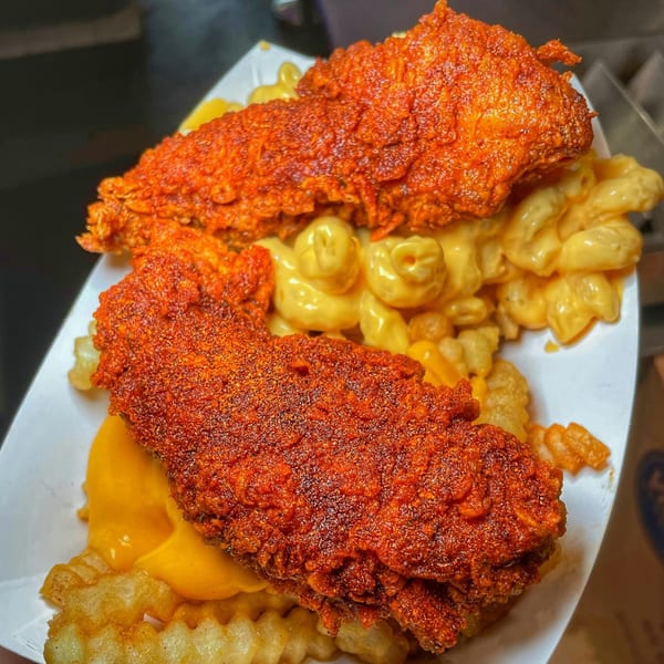 Baba's Hot Chicken tenders, mac and cheese, and waffle fries in a white paper tray.