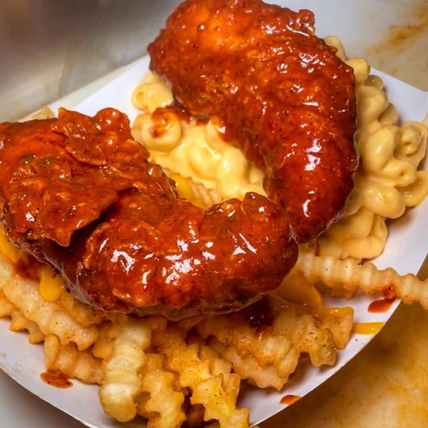 Baba's Hot Chicken tenders, crinkle fries, and mac and cheese, all covered in spicy sauce.