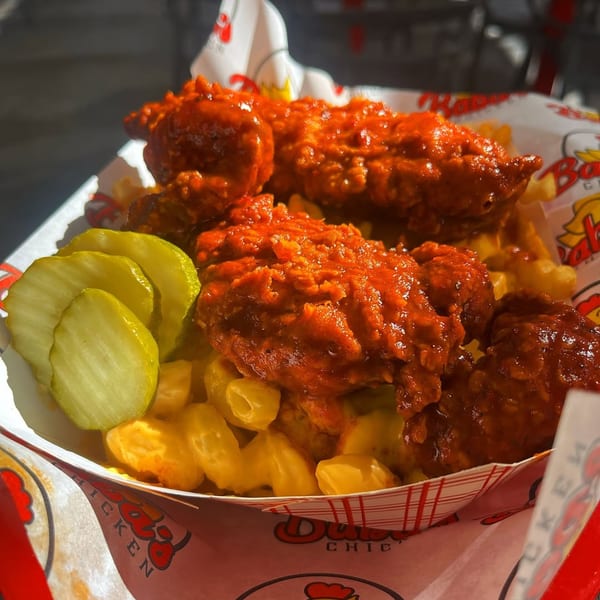 Baba's Hot Chicken tenders with mac and cheese and pickles in a branded paper tray.